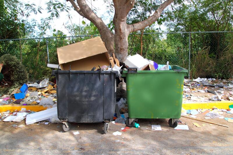 two large garbage dumpster full of garbage